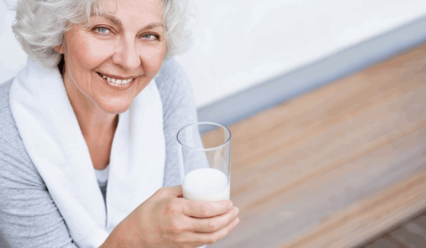 Seniorin trinkt ein Glas Milch